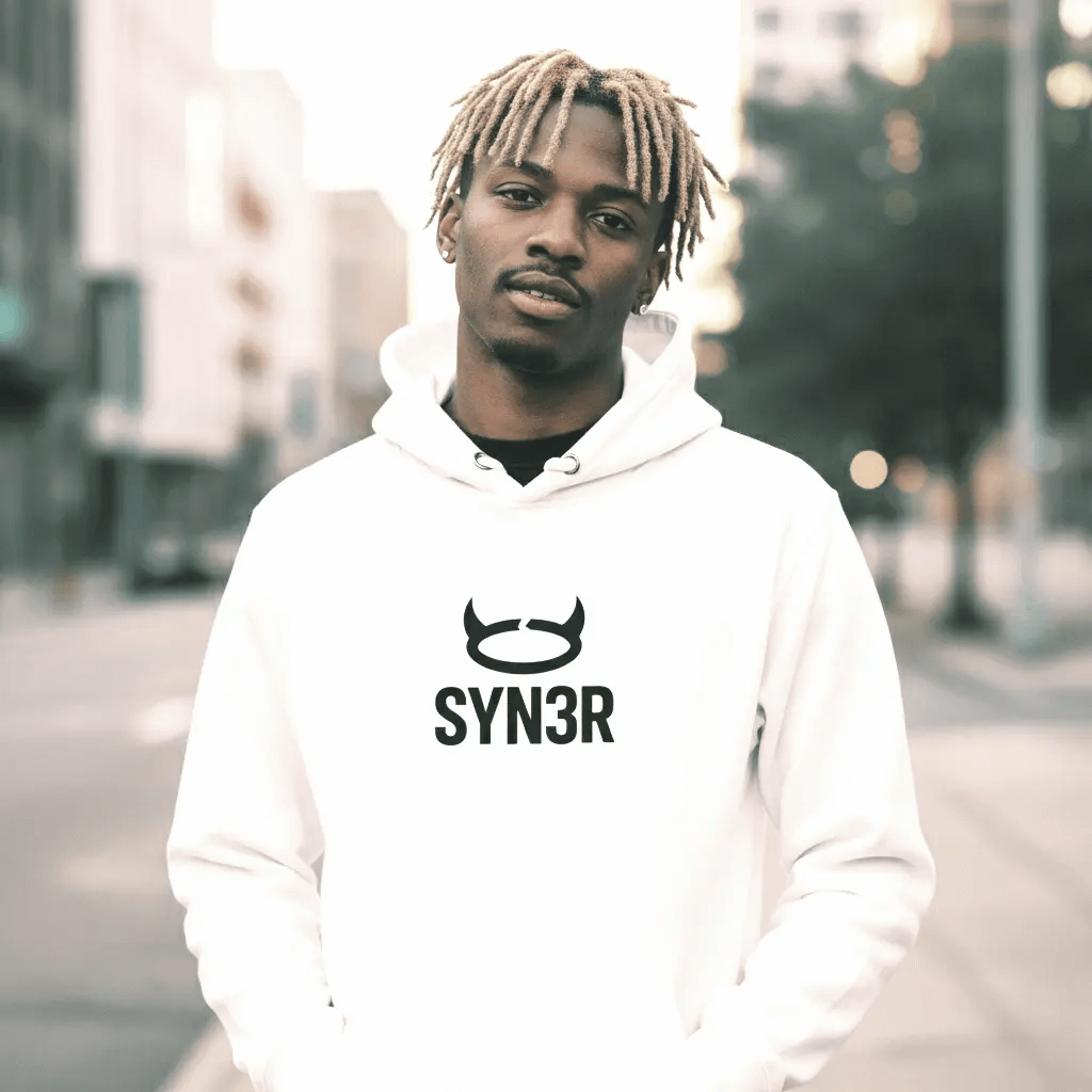 SYN3R HOODIE - White worn by model in urban streetwear setting with stylish design.